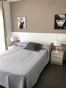 - un lit dans une chambre avec deux lampes et deux photos dans l'établissement Apartaments Colibri, à Cambrils 115 autres photos