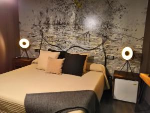una camera da letto con un letto con due lampade sopra di La Posada del Casar a Casar de Palomero