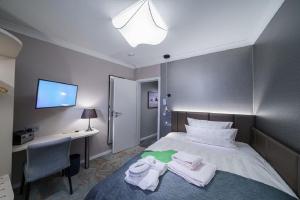 Una habitación de hotel con una cama con toallas. en Strandhotel Duhnen en Cuxhaven