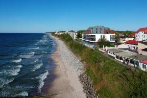 an aerial view of a beach with houses and the ocean at Sailor Residence in Ustronie Morskie