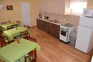eine Küche mit 2 Tischen und einem weißen Kühlschrank in der Unterkunft Penzion Chalupka in Štrba