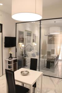 ein Wohnzimmer mit einem weißen Tisch und einem Fernseher in der Unterkunft La suite del centro storico in Matera