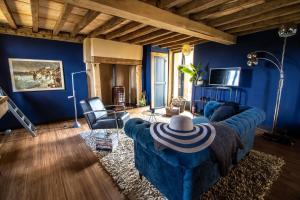uma sala de estar com paredes azuis e um sofá azul em Gites Briffaut em Saint-Hilaire-Fontaine