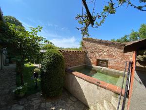 a swimming pool in the side of a brick building at Gite Les Buis de Saint Martin in Marssac-sur-Tarn