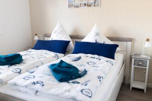 a bedroom with two beds with blue and white sheets at Dünenkieker Ferienwohnung in Lubmin