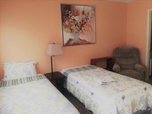 a bedroom with two beds and a chair and a painting at Venice Villas * Studio #60 in Venice