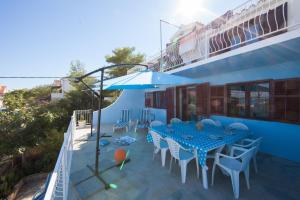 a patio with a table and chairs and an umbrella at The Sea House Apartments in Vis