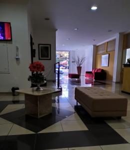 a living room with a couch and a table at Hotel San German in Ubá