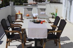einen Tisch und Stühle auf einer Terrasse mit Essen drauf in der Unterkunft App Sanny with nice terrace in Malinska