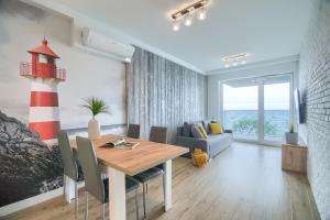 a dining room with a table and a lighthouse at Sailor Residence in Ustronie Morskie