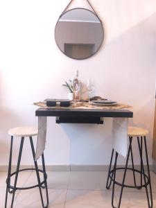 a table with two stools and a mirror on the wall at Studio Vieil Antibes - Saint Antoine in Antibes