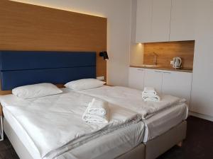 sypialnia z dużym białym łóżkiem z ręcznikami w obiekcie Seaside Park Resort w Kołobrzegu