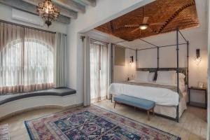 1 dormitorio con cama con dosel y alfombra en Casa Delphine, en San Miguel de Allende