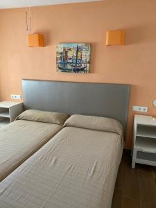 a bedroom with two beds and a painting on the wall at Apartamentos SOL y PLAYA Torremolinos in Torremolinos