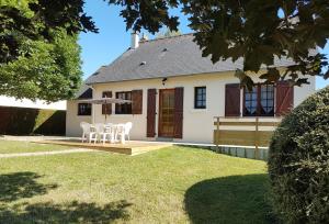 a house with a table and chairs in the yard at La Quietude in Amboise