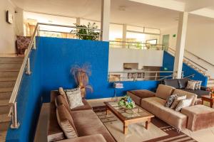 a living room with a couch and a blue wall at Caldas Park & Hotel Caldas Novas in Caldas Novas