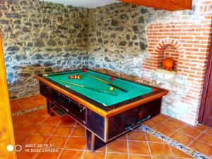 a pool table in a room with a brick wall at CASA AMPLIA CON JARDÍN Y APARCAMIENTO G-100147 in Ajo