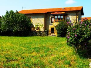 a house with a green yard with flowers at CASA AMPLIA CON JARDÍN Y APARCAMIENTO G-100147 in Ajo