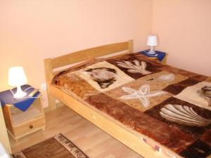 a bedroom with a bed and two night stands with lamps at Willa Muszelka Karwia in Karwia