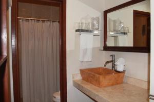 a bathroom with a sink and a mirror and a toilet at Cabanas Maria Del Mar in Isla Mujeres