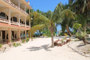un complejo en la playa con palmeras en Cabanas Maria Del Mar en Isla Mujeres