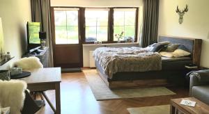 ein Schlafzimmer mit einem Bett, einem Sofa und einem Fenster in der Unterkunft Alpina Inzell Wohnung 454 in Inzell