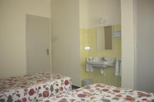 baño con 2 camas, lavabo y espejo en Hostal Torre Mar, en Salou