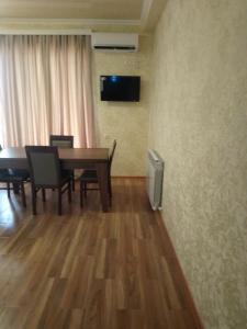 jadalnia ze stołem, krzesłami i telewizorem w obiekcie Apartment In Kutaisi Center w Kutaisi