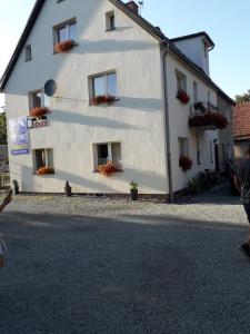 a white building with flower boxes on the windows at U Eli in Wambierzyce +13 photos