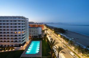 um hotel com uma piscina ao lado de uma praia em Hotel Apartamentos Bajondillo em Torremolinos