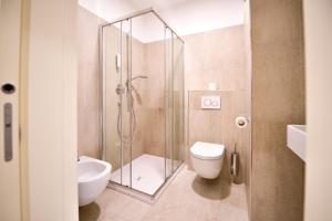 a bathroom with a shower and a toilet and a sink at Pension Martha in Postal +77 photos