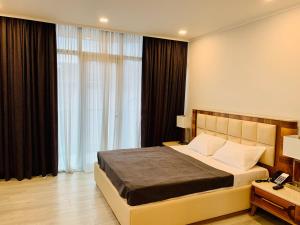 バトゥミにあるHotel Tsereteli Palaceのベッドルーム1室(ベッド1台、大きな窓付) +30枚の写真