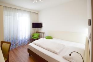 a bedroom with a white bed and a window at Pension Martha in Postal