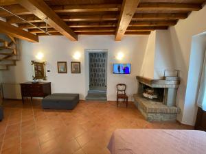 sala de estar con chimenea y TV en Sant Andrea Country Cottage en Barberino di Mugello