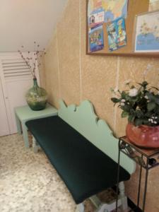 un banco verde en una habitación con un jarrón en Hostal Torre Mar, en Salou