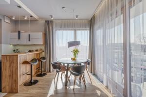 a kitchen with a table and chairs and a large window at atHome Suites in Kraków