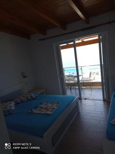 1 dormitorio con cama y vistas al océano en Wave n' Sea Apartments, en Himare