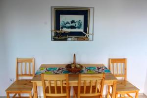- une table en bois avec des chaises et une corbeille de fruits dans l'établissement Blue Mediterranean Apartments, à Sveti Stefan