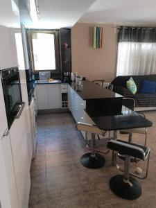 a kitchen and living room with a table and a couch at APARTAMENTO CON WIFI Y PISCINA EN BLANES FRENTE A LA PLAYA - Costa Brava in Blanes
