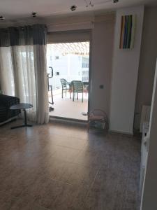 a living room with a view of a table and a patio at APARTAMENTO CON WIFI Y PISCINA EN BLANES FRENTE A LA PLAYA - Costa Brava in Blanes