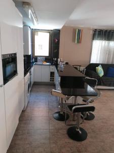 a kitchen and living room with a table and chairs at APARTAMENTO CON WIFI Y PISCINA EN BLANES FRENTE A LA PLAYA - Costa Brava in Blanes