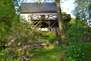 a garden with a house and flowers in front at Trzy Strumyki in Kąty Bystrzyckie