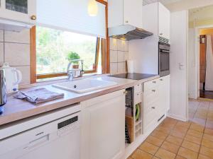 a white kitchen with a sink and a window at 6 person holiday home in Gilleleje in Gilleleje