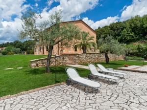 a group of white chairs sitting on a stone patio at Farmhouse in Montoro near Montoro Castle in Narni
