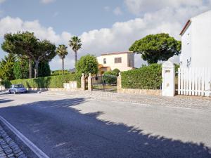 a street with a white house and a fence at Modern villa in an exclusive residential area with a private swimming pool in Vilamoura