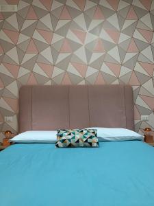 een slaapkamer met een bed met een geometrische muur bij Dimora D'Este in Tivoli