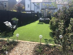 einen Hinterhof mit einem Rasen mit Minigolfbällen in der Unterkunft Victorian Cottage in Deal + 6 Fotos