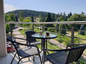 een tafel en stoelen op een balkon met uitzicht bij Happy in Vrnjačka Banja