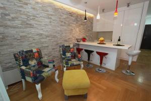 a living room with chairs and a kitchen with a counter at Luxury Apartment Big Blue in Budva