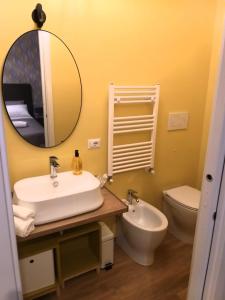 een badkamer met een wastafel, een toilet en een spiegel bij Dimora D'Este in Tivoli